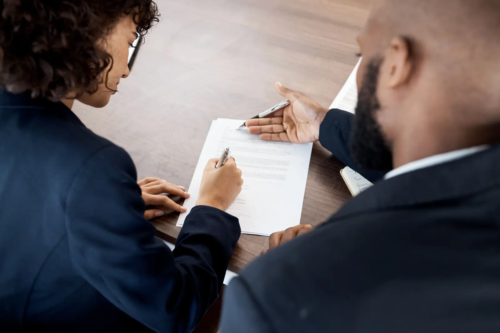 An HR advisor guides a client through signing an employment contract