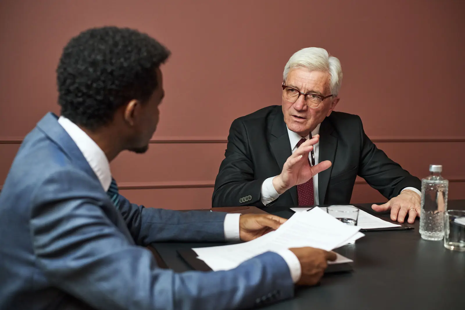 Two men negotiating across a boardroom table
