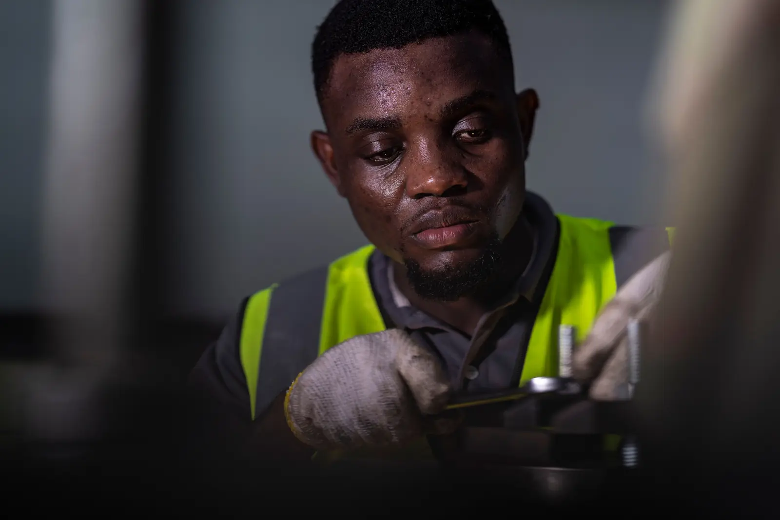 A factory worker in a hi-vis vest operating machinery
